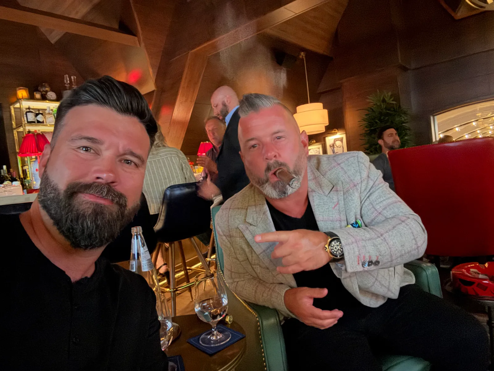 Two friends seated together at a cigar gathering