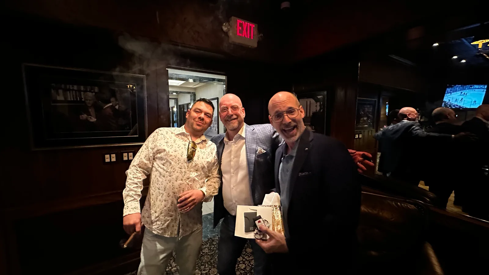Guests posing beside the bar at a Smoke event