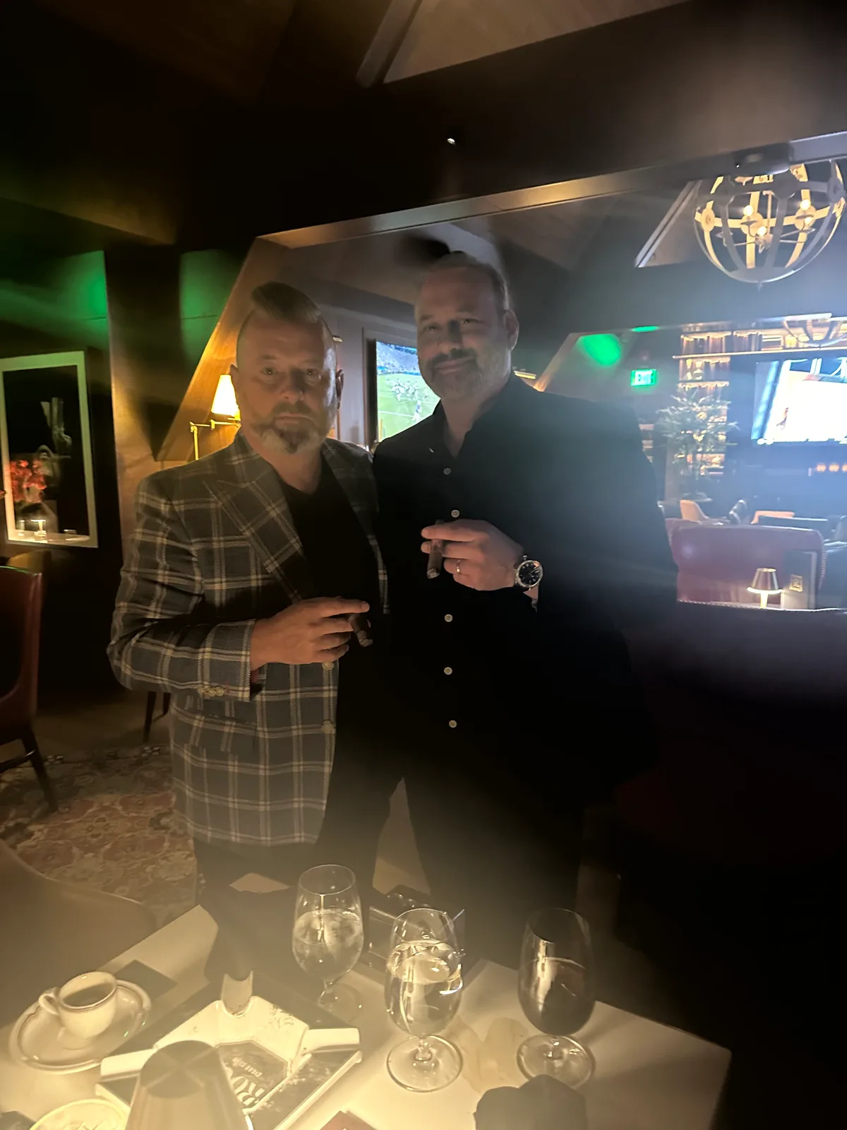 Two guests enjoying cigars and conversation in the lounge