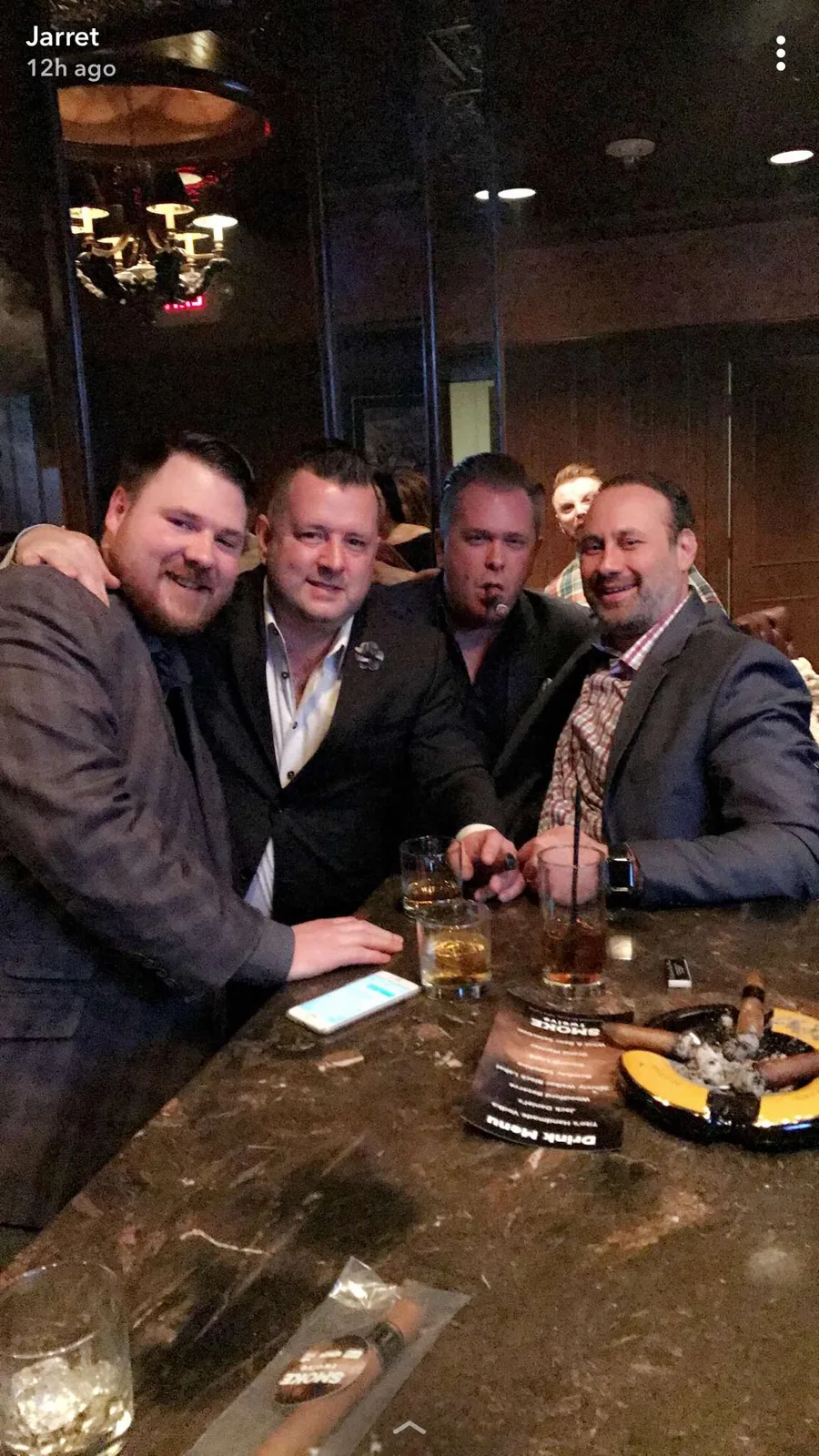 A group of friends gathered around a cigar lounge table